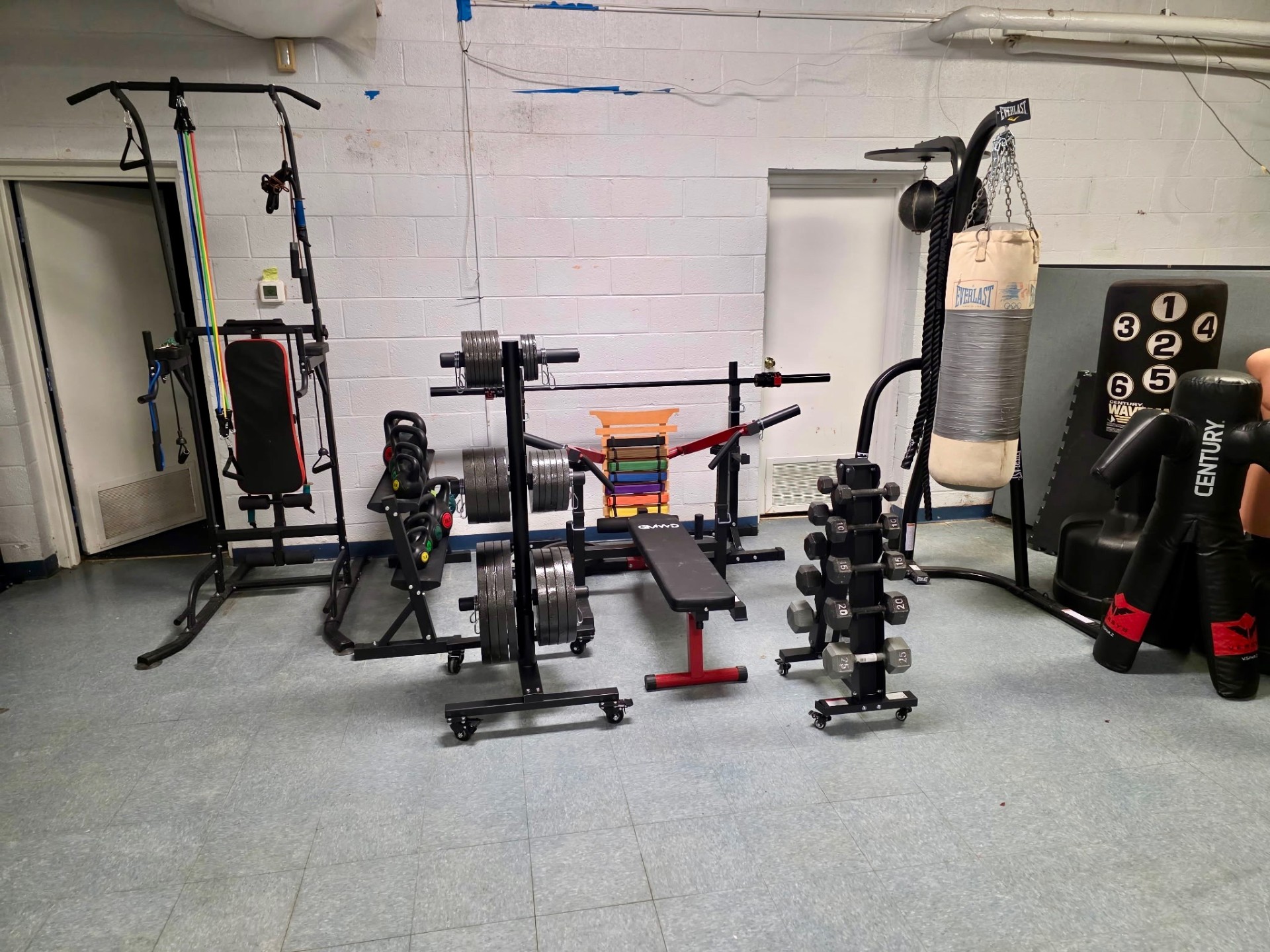 Full equipment area with bags, weights, and rack